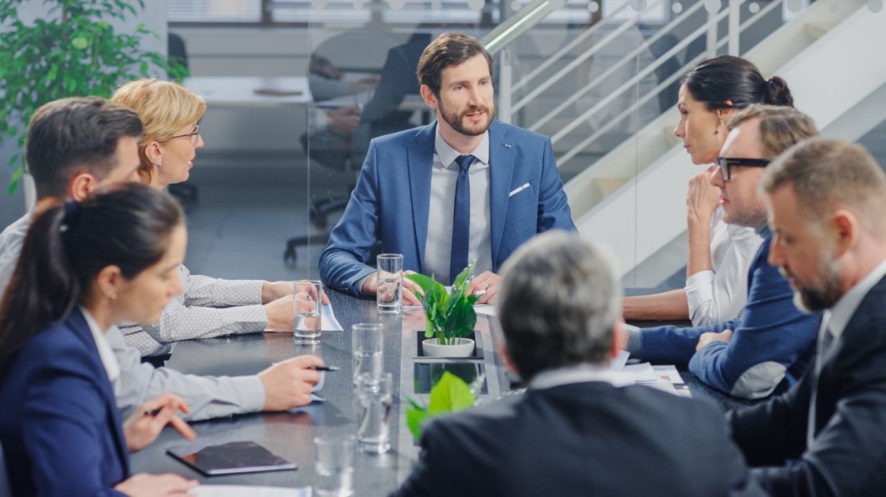 Professional business meeting with ICT consultants discussing technology solutions around a conference table